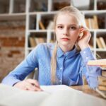 Woman Sitting Next to Table and Right Hand on Ear