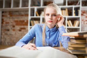 Woman Sitting Next to Table and Right Hand on Ear