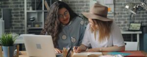 Two women working on a laptop at a desk