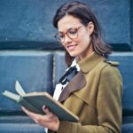 Woman In Brown Suede Peacoat Reading A Book